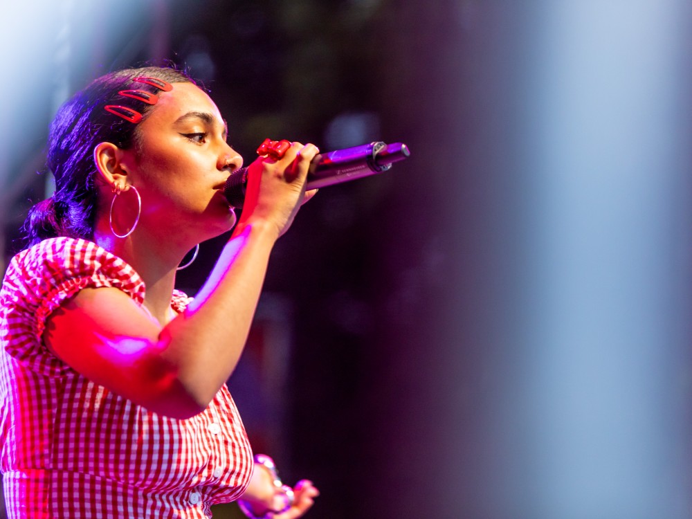 Chovo hält ein Mikrofon an den Mund und singt beim Kultursommer Wien 2025. 