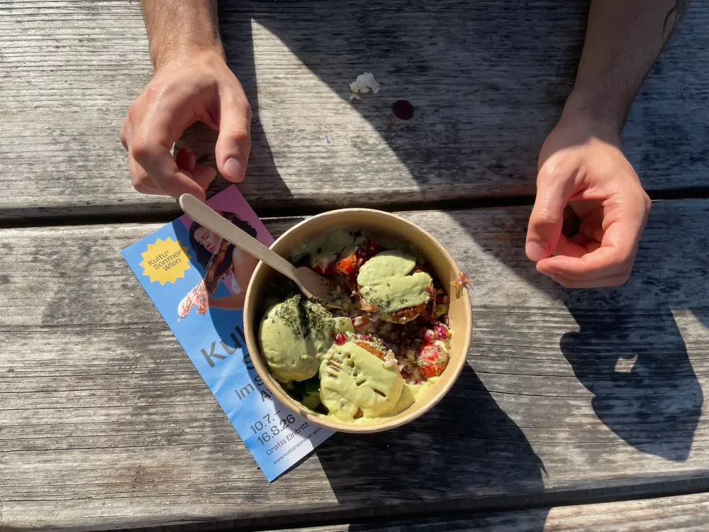 Am Bild ist eine Falafelbowl und Kultursommerprogramm zu sehen. 