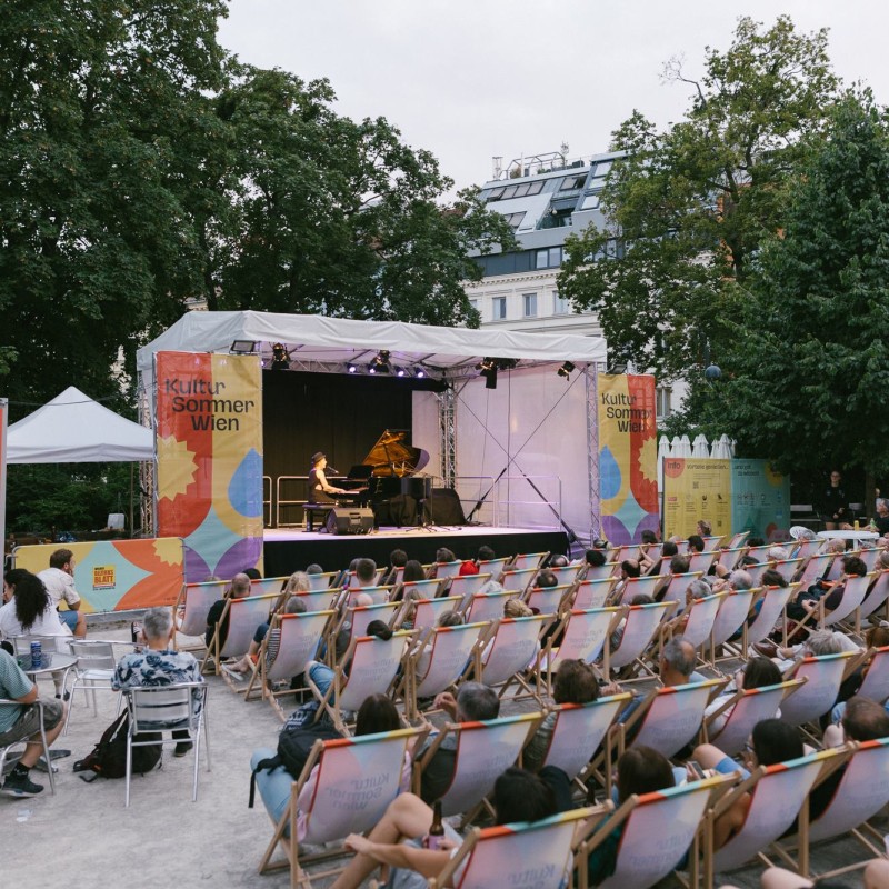 Foto: Judith Stehlik Die Musikerin Laura Braun sitzt am Piano und singt für das Publikum im Reithofferpark Balladen.