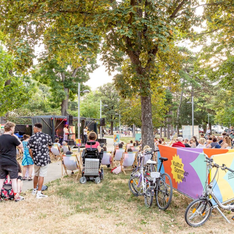 Foto: Judith Stehlik Die Band Deep Talk steht auf der Bühne im Hyblerpark. Im Vordergrund stehen Fahrräder. Das Publikum sitzt in Liegestühlen und auf Decken am Boden.