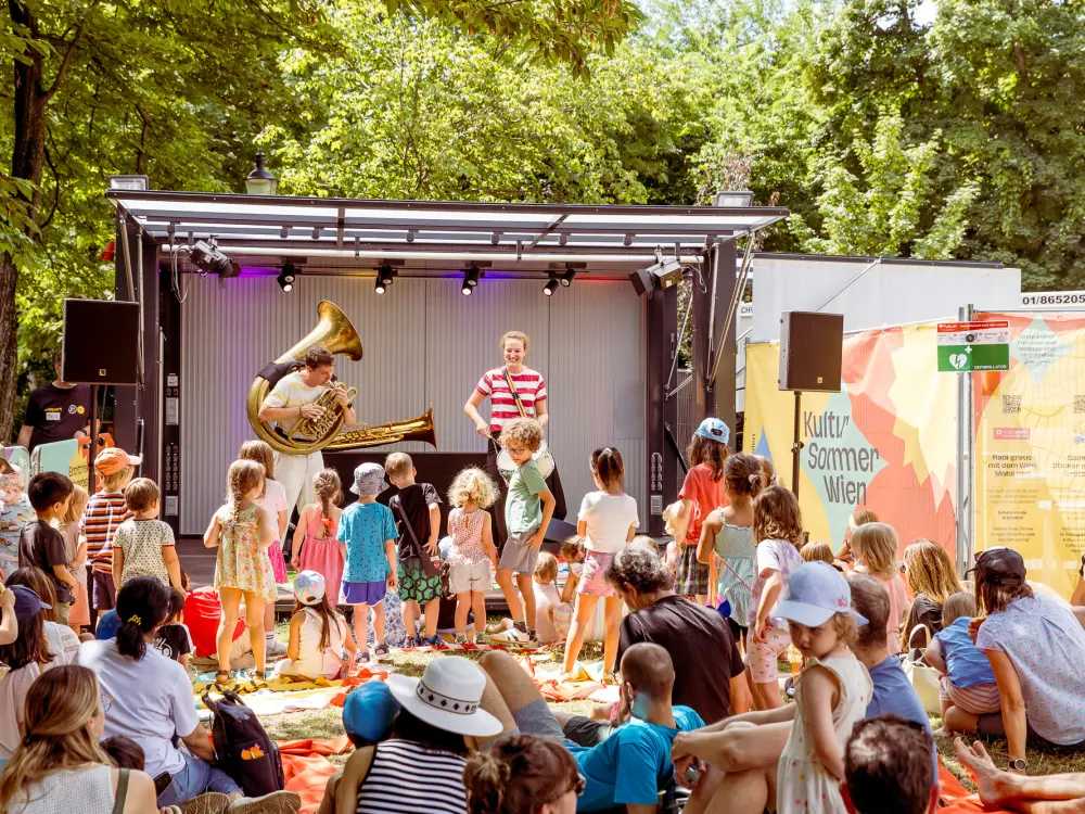 Karin Meissl & Markus Nimmervoll: Karin Meissl und Markus Nimmervoll performen beim Kinderfest im Waldmüllerpark. Sie spielen unter anderem auf einer Tuba. 