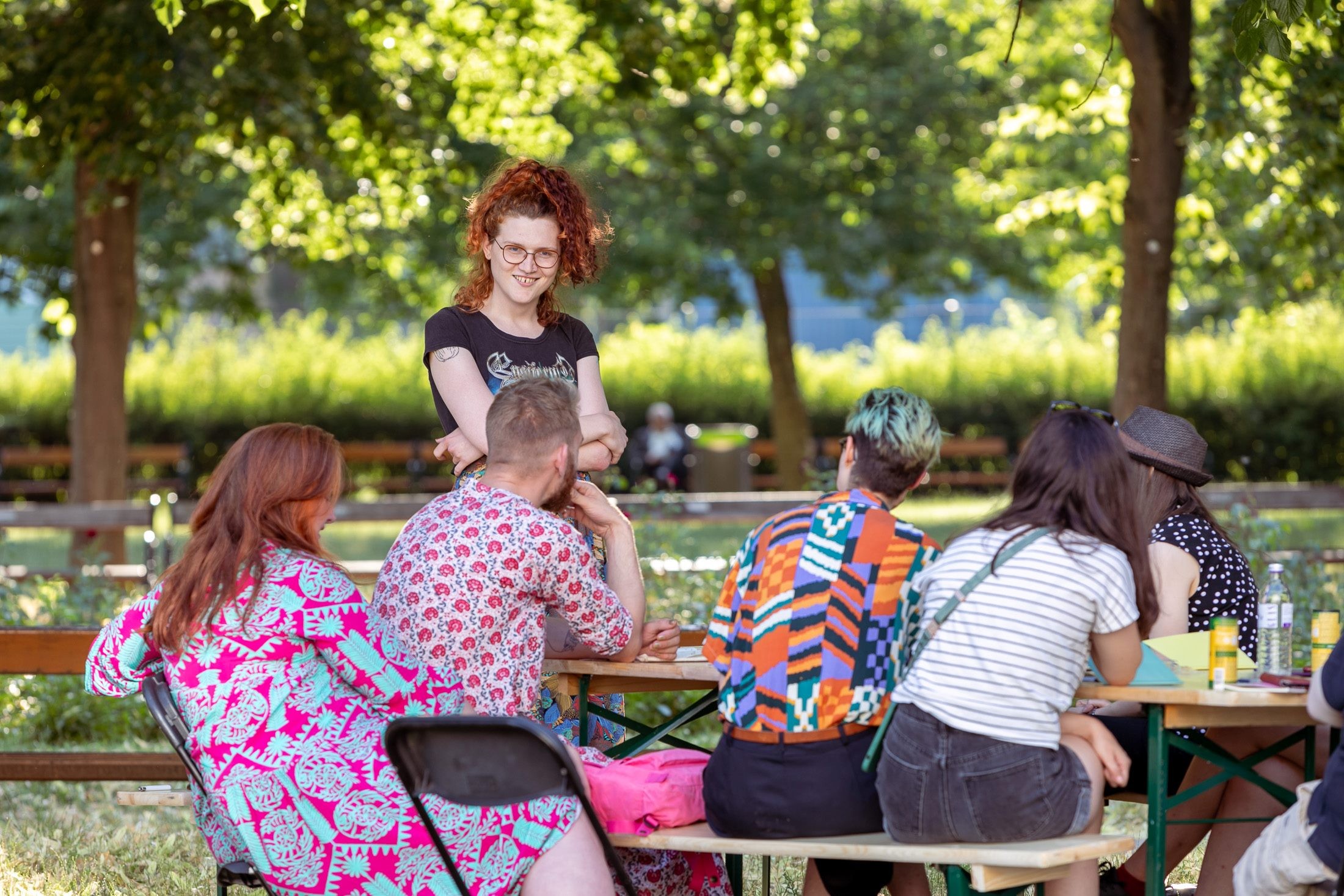 Workshop-Teilnehmende sitzen um einen Tisch. Nathalie Rettenbacher erzählt über die Kunst des Kabaretts. 